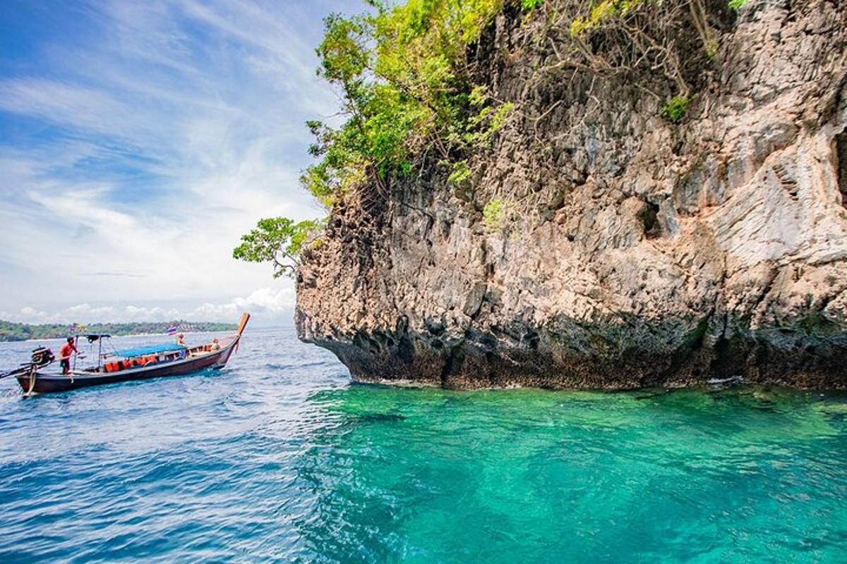 a boat in the water next to a cliff