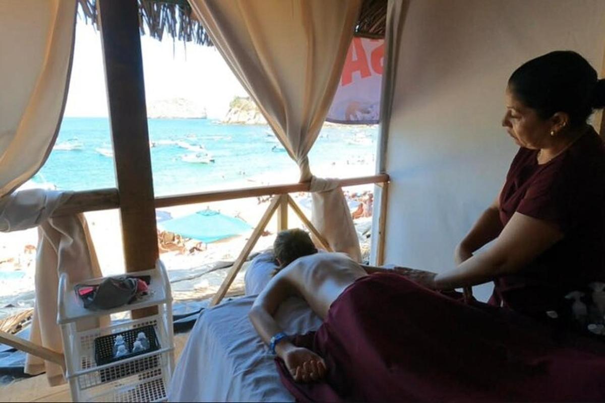 a woman sitting in a bed in front of a beach