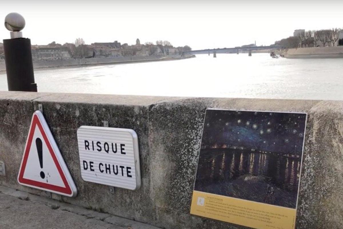 a sign on a wall next to a body of water