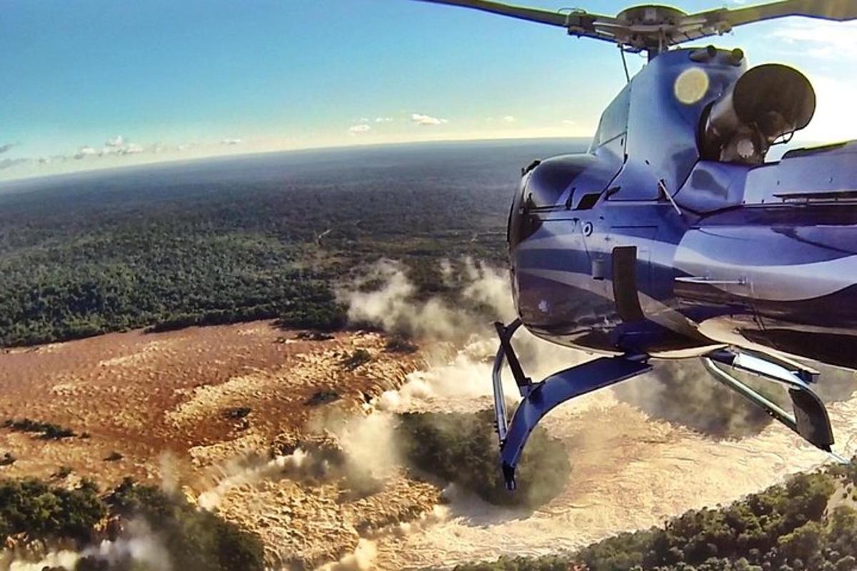 Ein blauer Hubschrauber fliegt über ein Feld