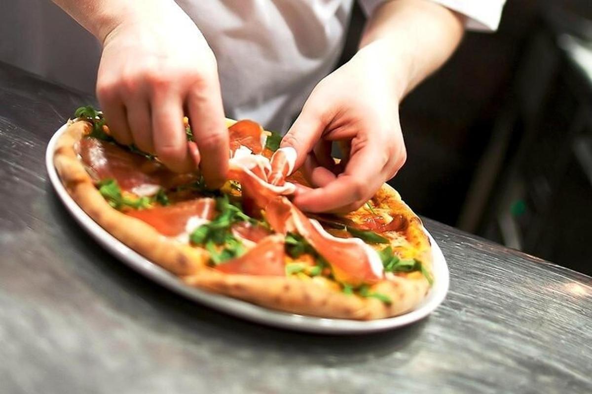 člověk dělá pizzu na talíři