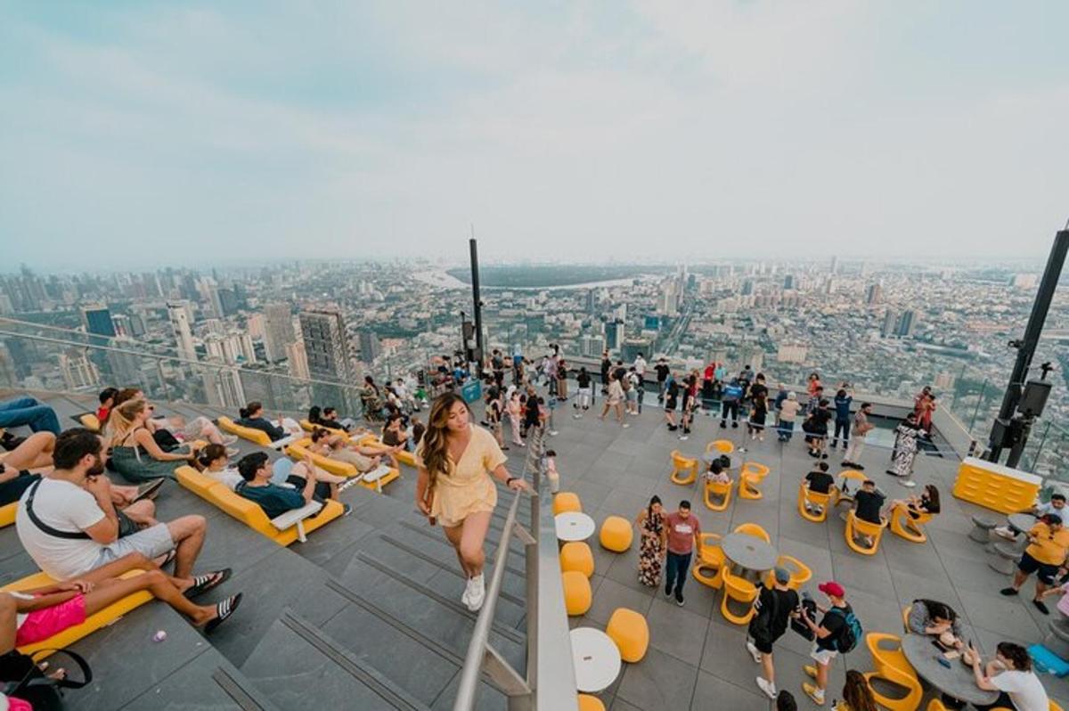 una multitud de personas sentadas en el borde de una torre