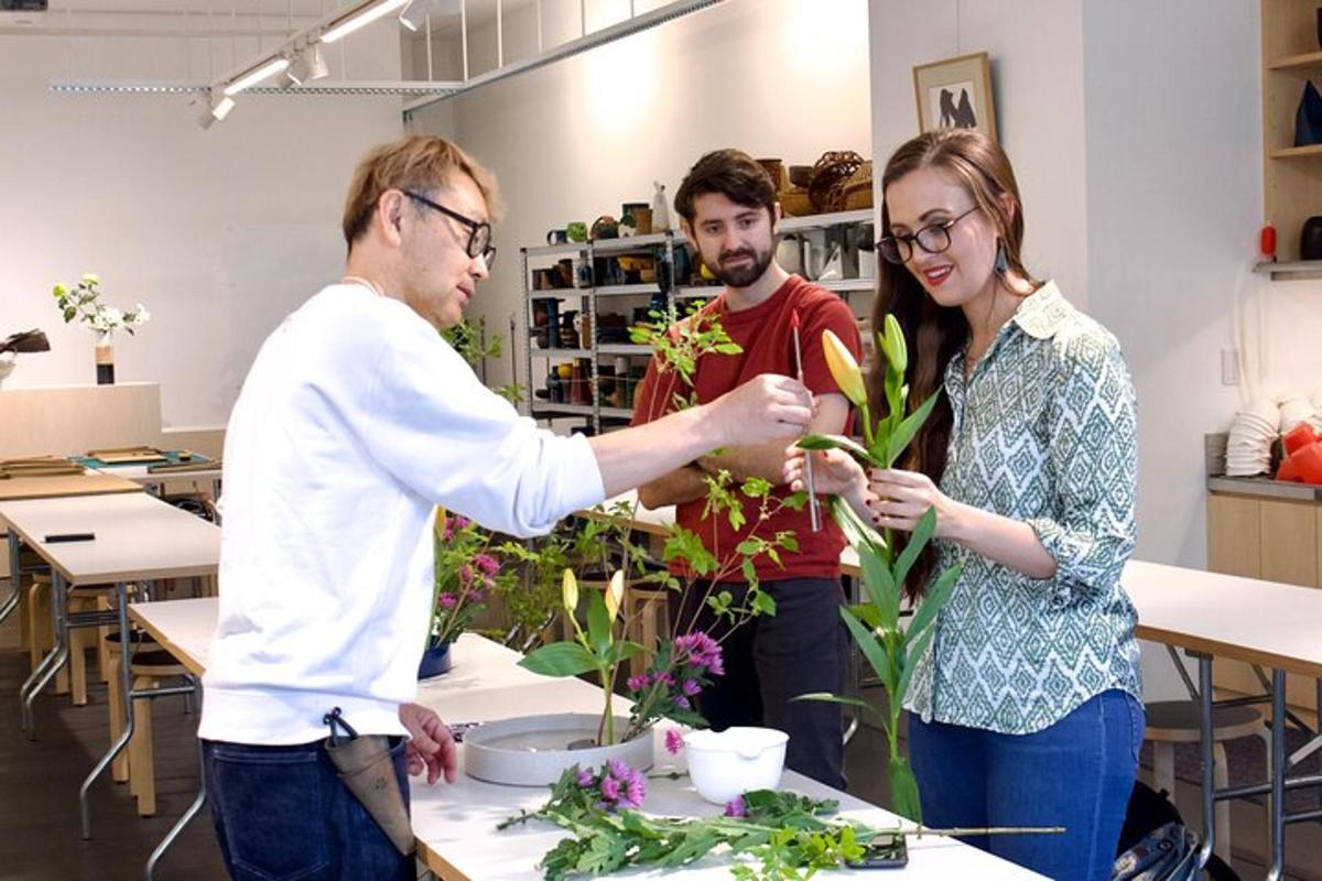 deux hommes et une femme travaillant sur une composition florale
