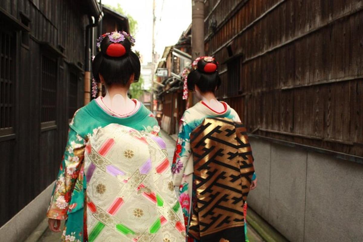 two geisha walking down a street wearing kimonos