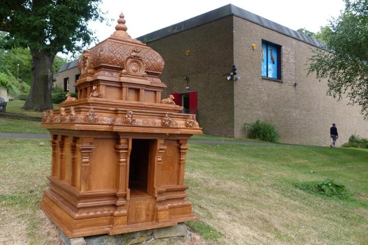 a wooden structure in a yard in front of a building