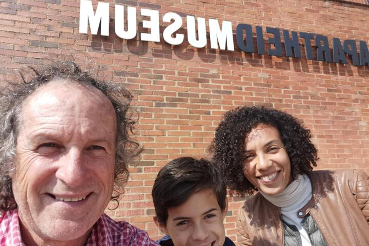 two men and a woman standing in front of a brick building