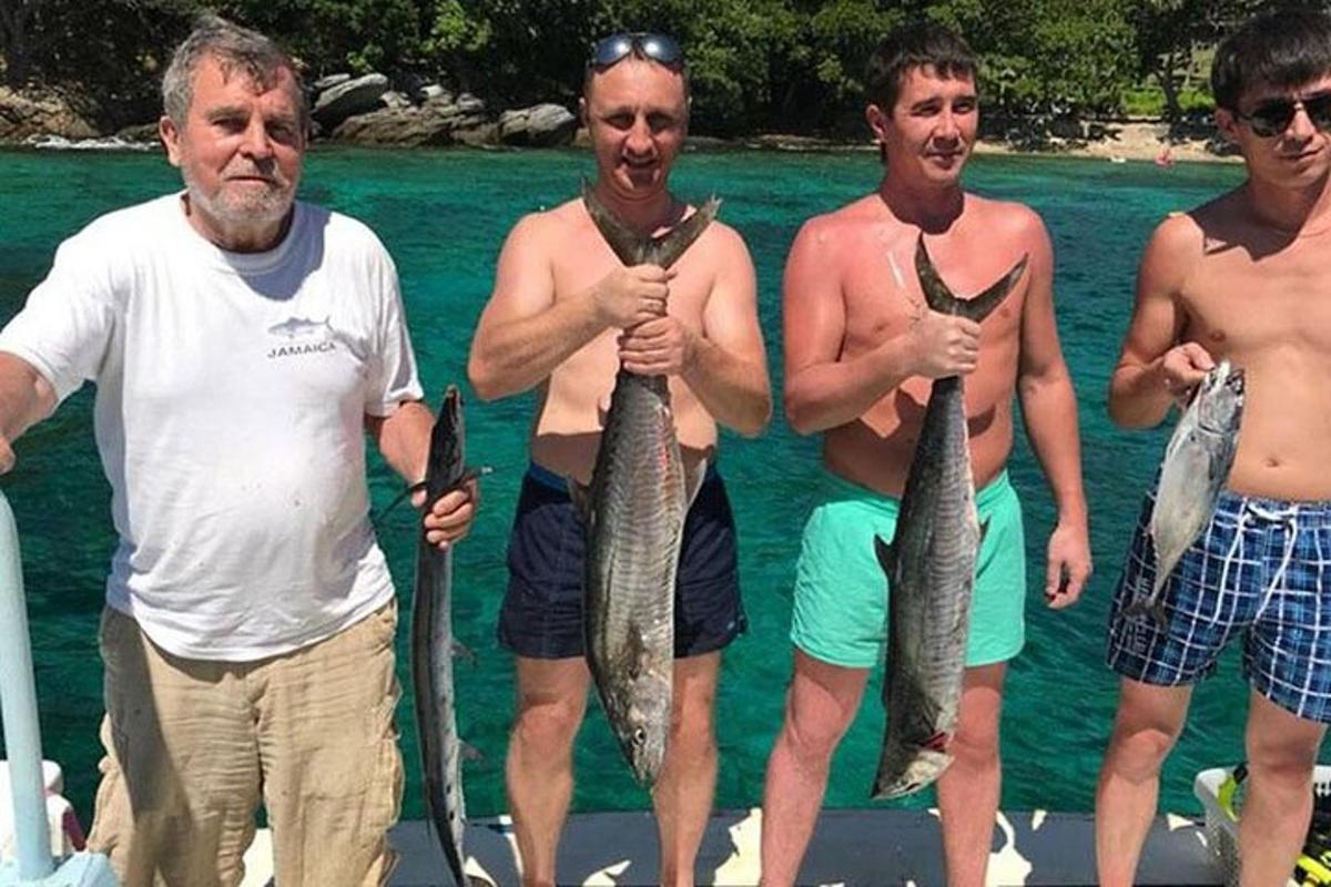 un gruppo di uomini che tengono dei pesci nell'acqua