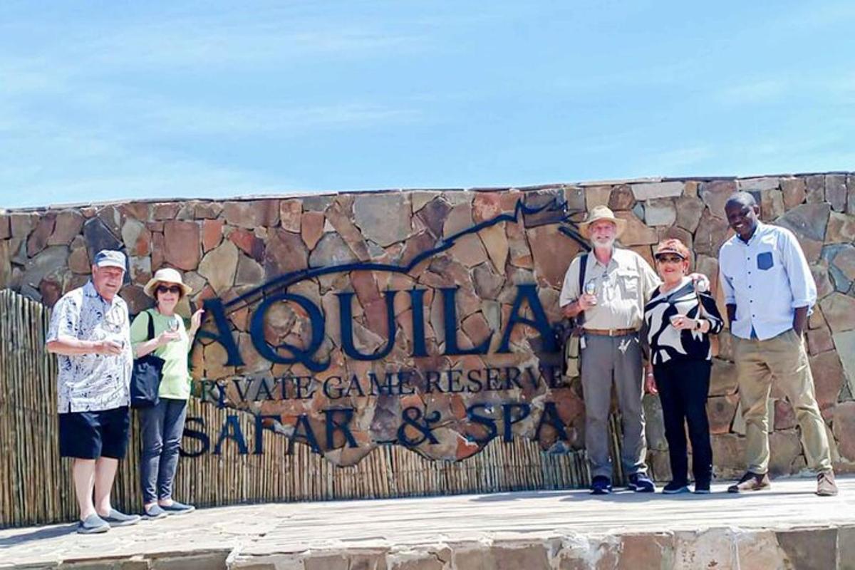 um grupo de pessoas em pé em frente a um muro de pedra