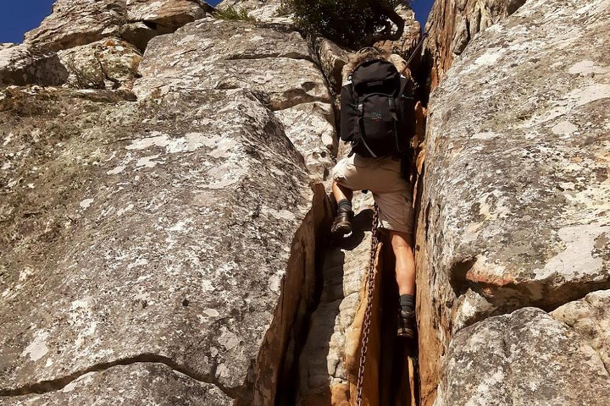 um homem com uma mochila escalando uma montanha rochosa