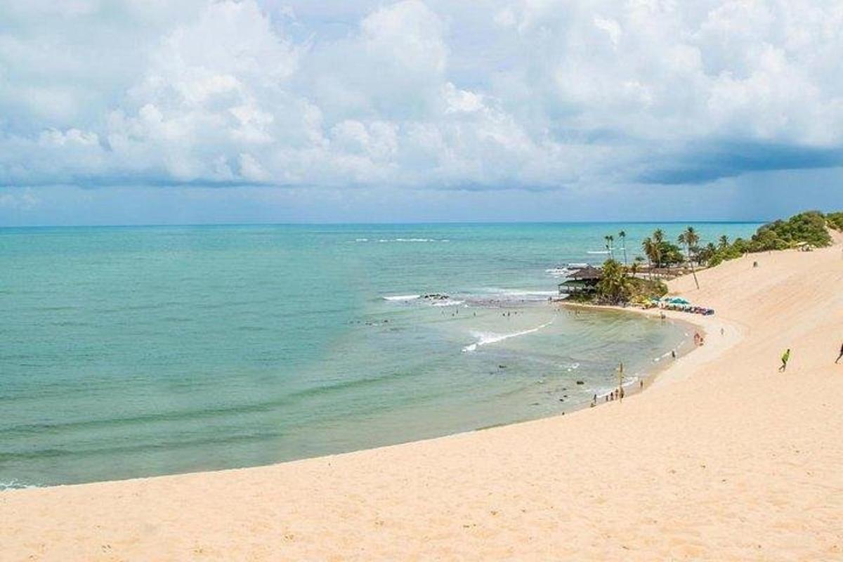 a group of people on a beach with the ocean