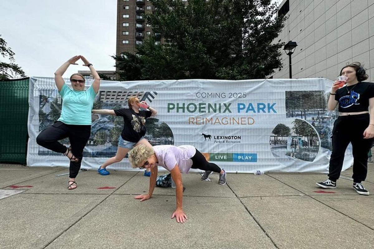 a group of people doing a yoga pose on the sidewalk