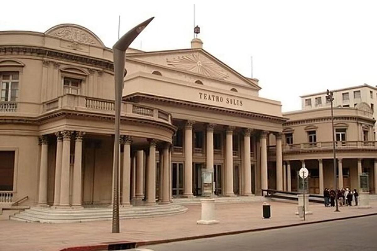 Un gran edificio con gente parada frente a él.