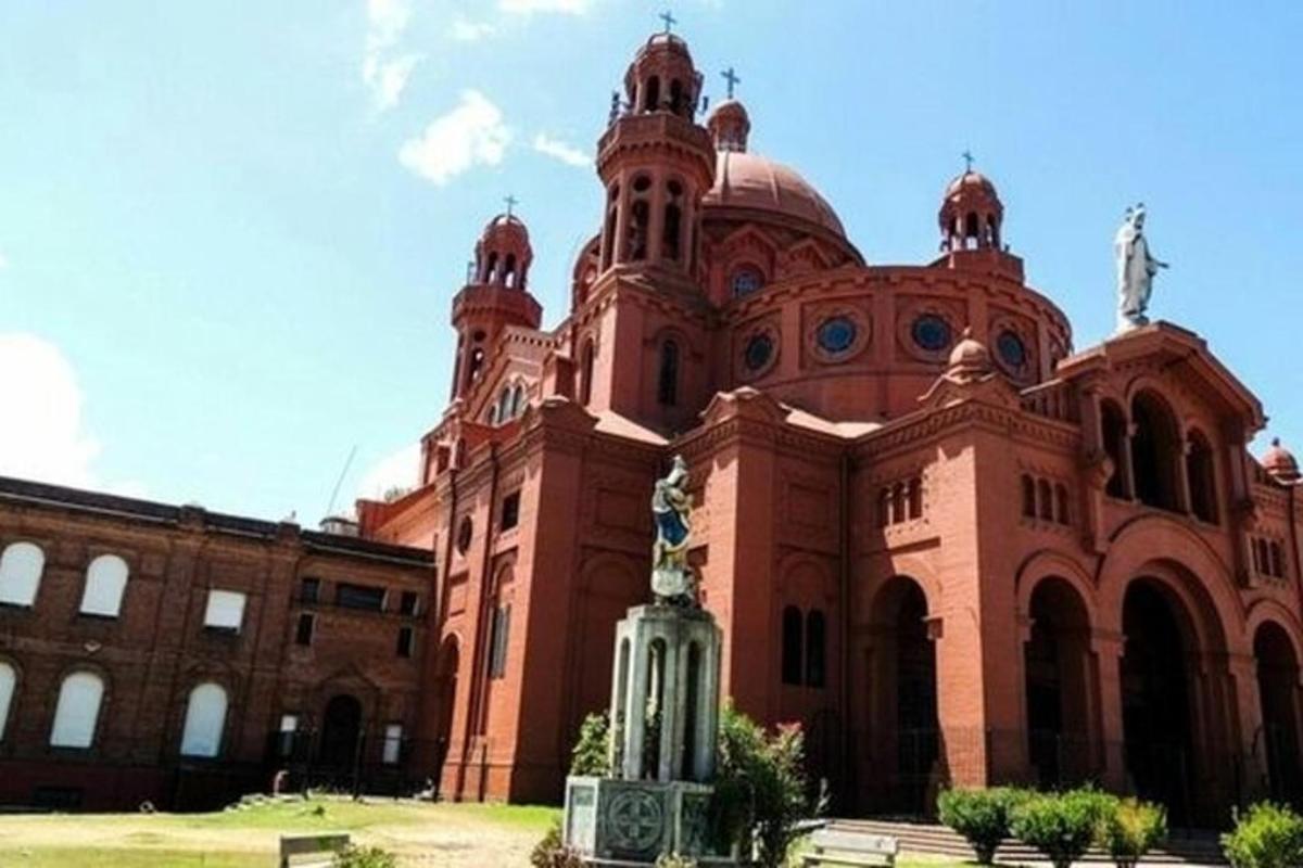 un grande edificio in mattoni con una statua di fronte