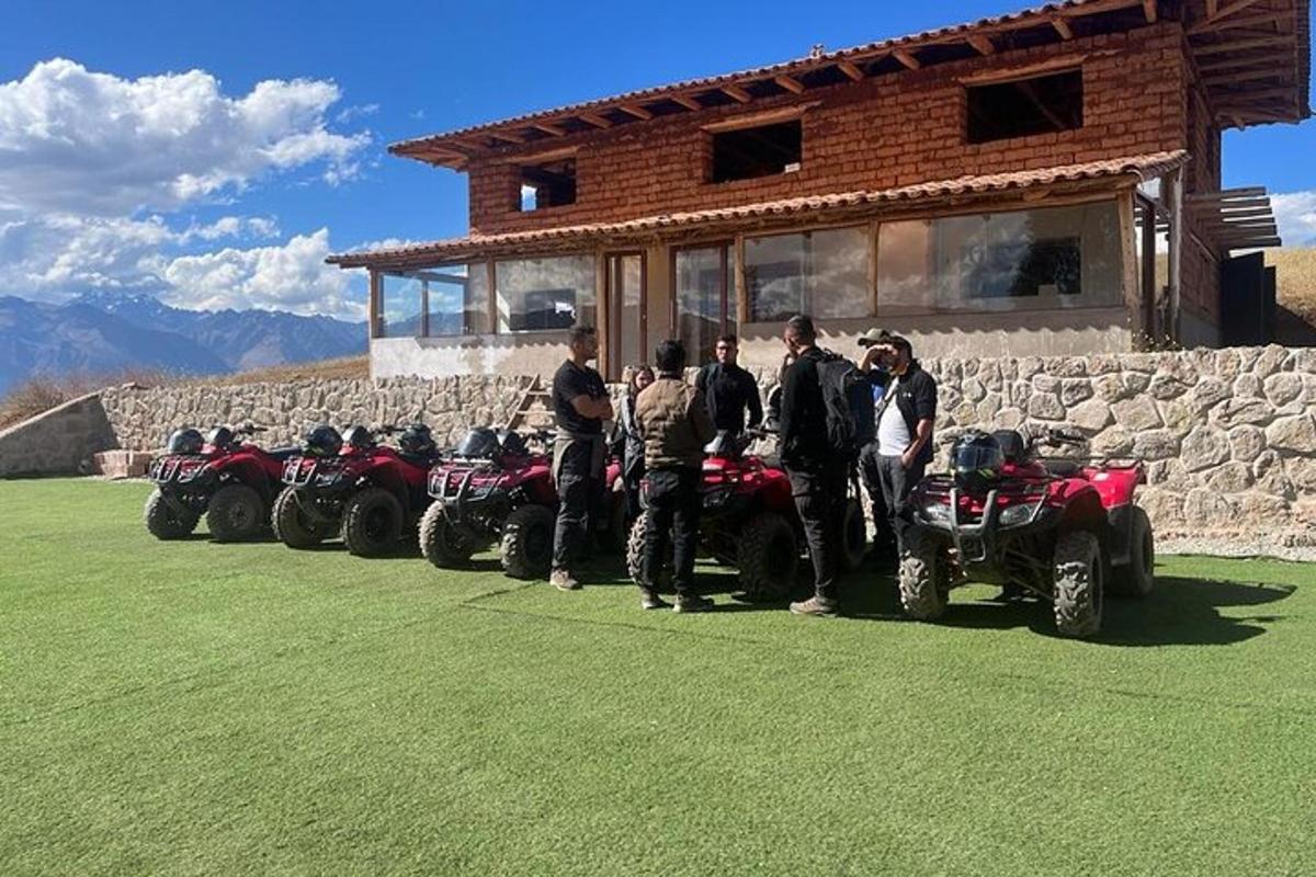un grup de oameni care stau în fața unui rând de ATV-uri