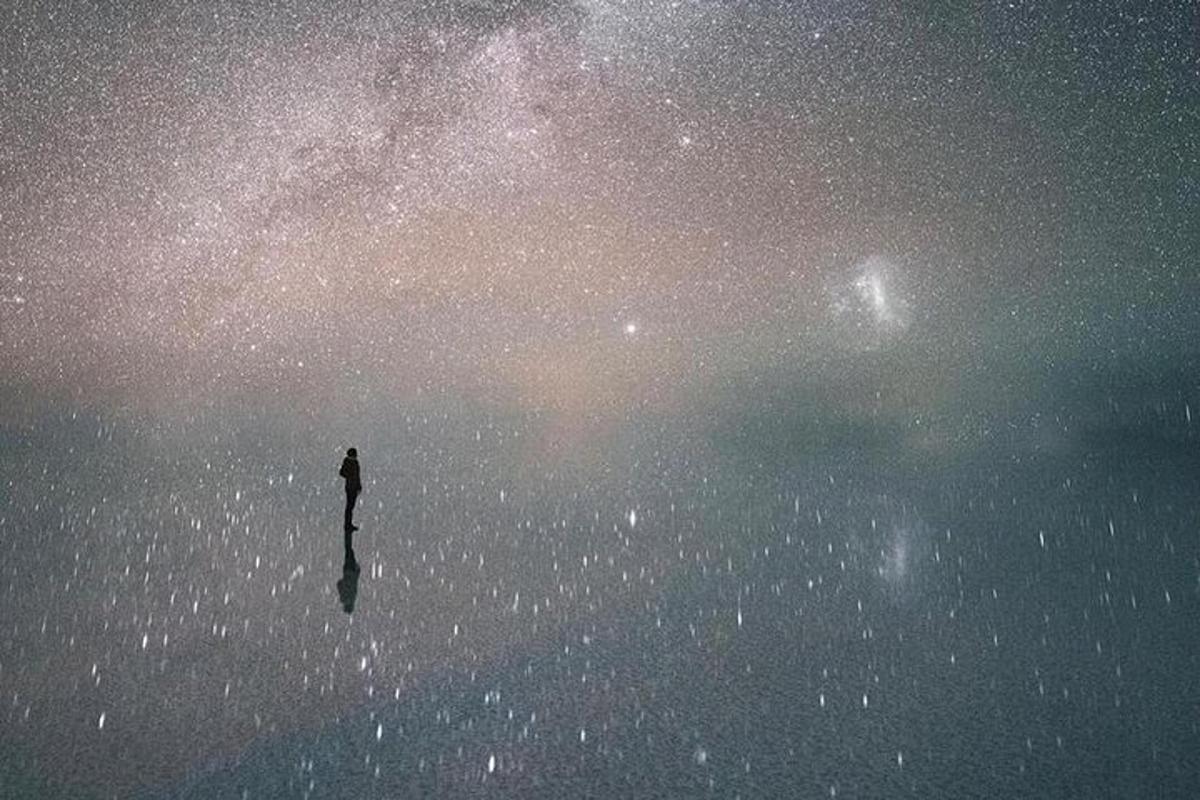 a person standing in the water under a starry sky