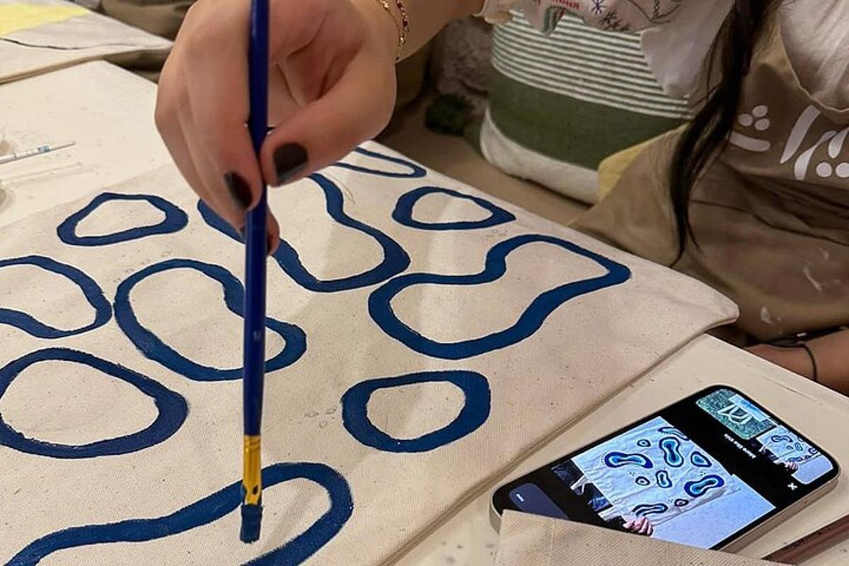 osoba držící tužku na ceduli s mobilním telefonem