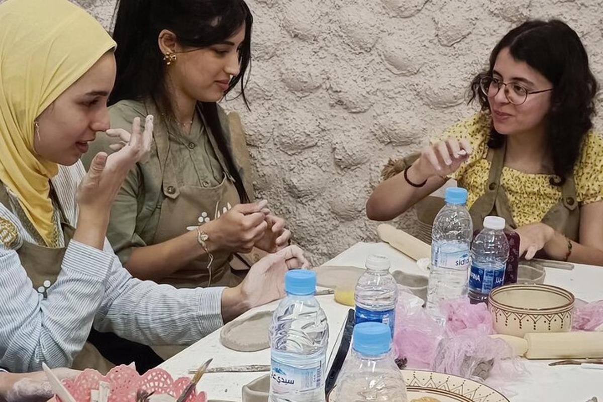 tři ženy sedící u stolu s lahvemi s vodou