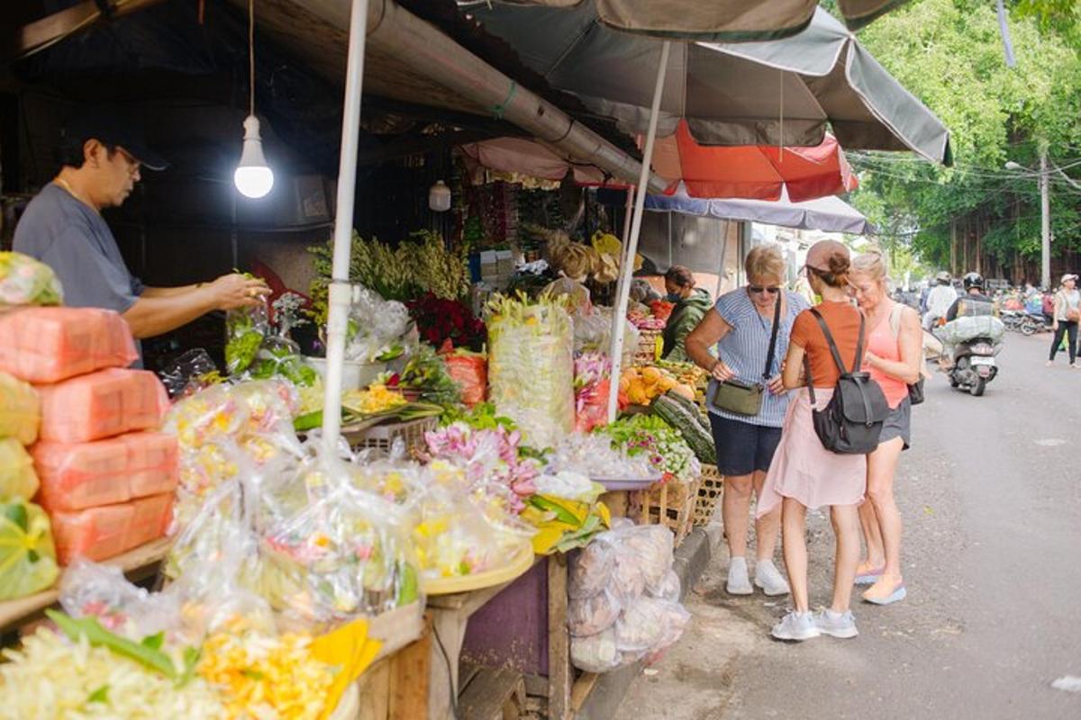 un grup de persones al voltant d'una parada de fruites i verdures