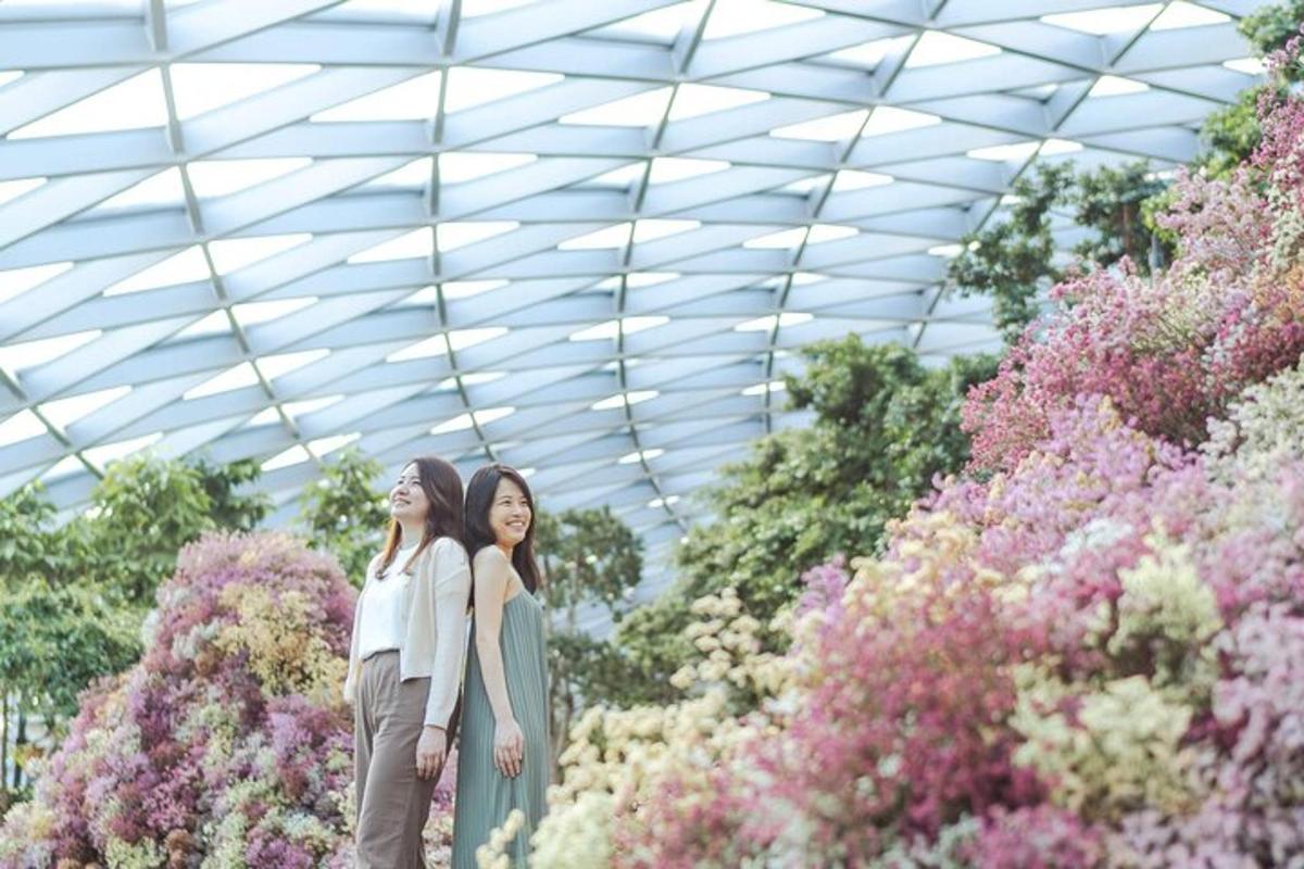 two women standing in front of a display of flowers