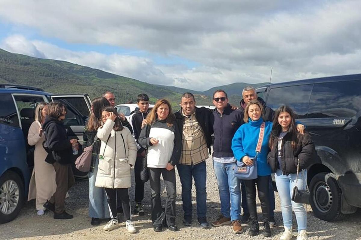 un grup de oameni care stau în fața unui autobuz