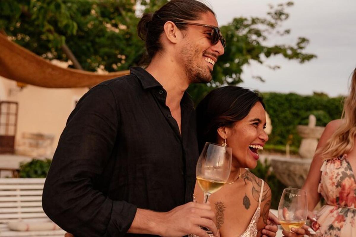 un uomo e una donna che tengono in mano un bicchiere di vino