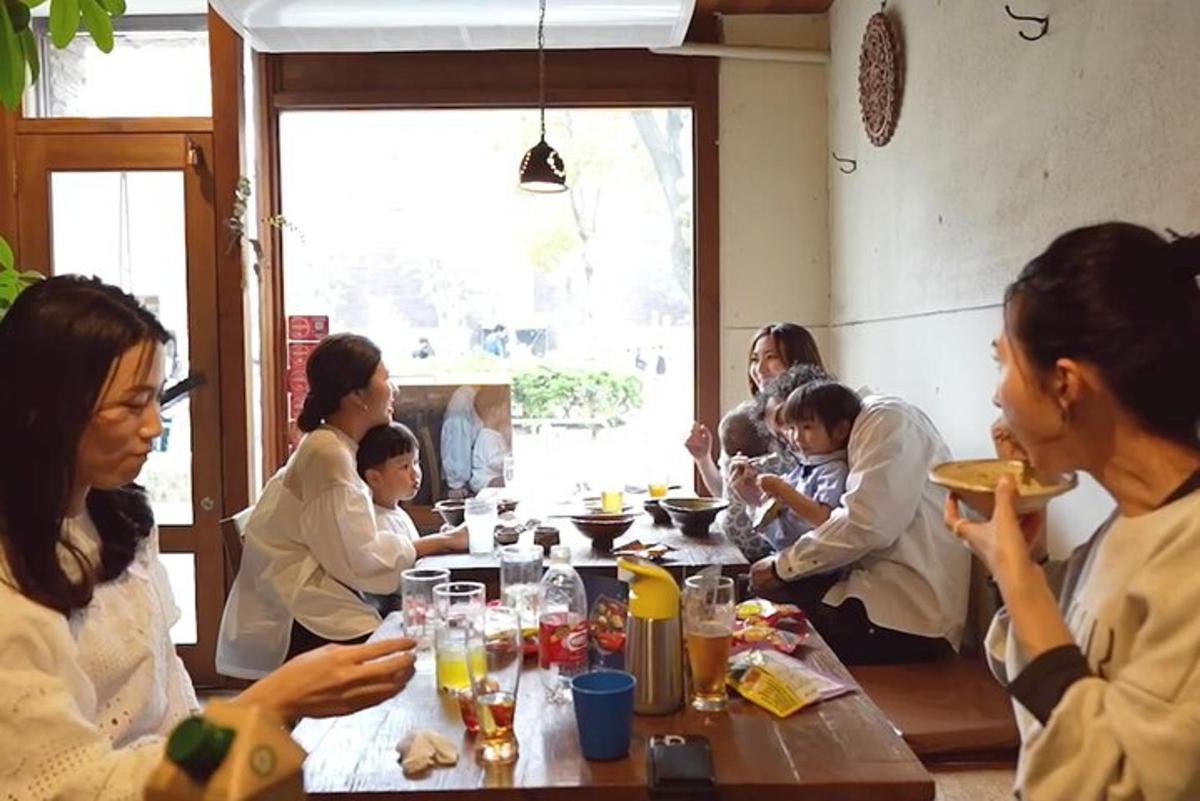 Un grupo de personas sentadas en una mesa comiendo comida