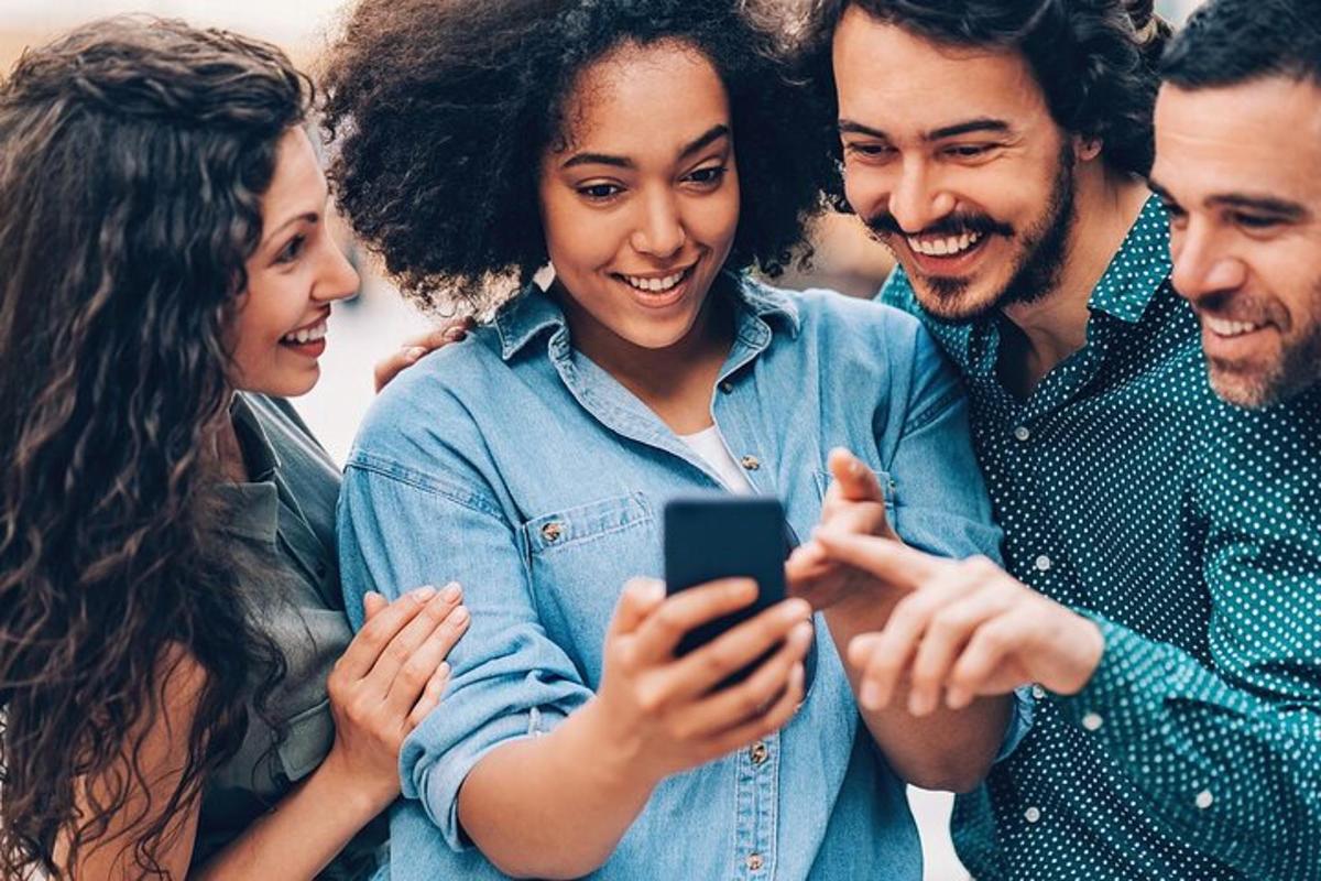 a group of people looking at a cell phone