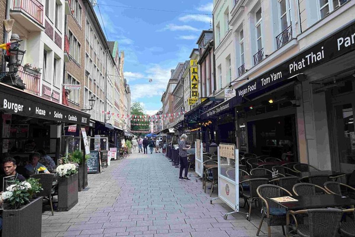 a city street with tables and chairs and buildings