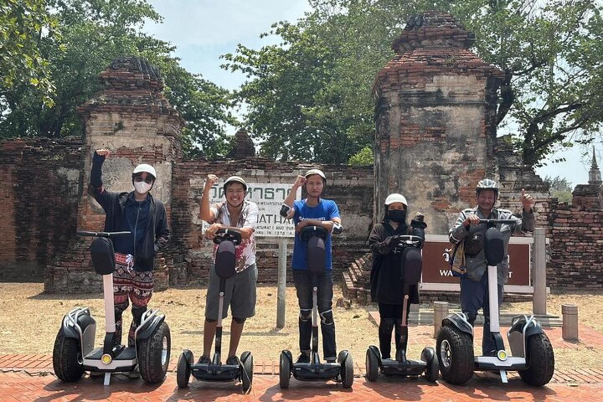 skupina lidí jedoucích na segwayích před budovou