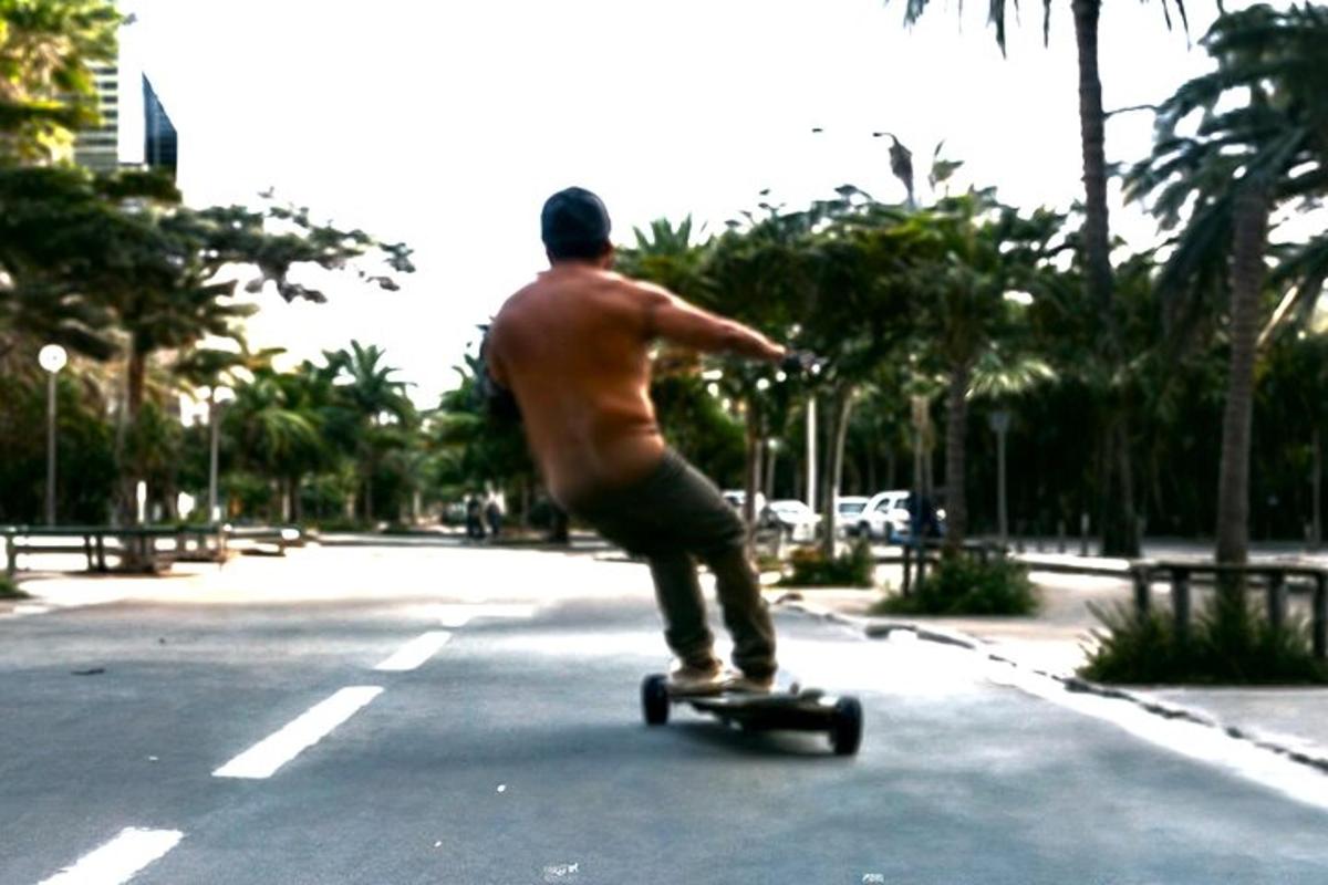 un bărbat fără cămașă mergând pe un skateboard pe o stradă