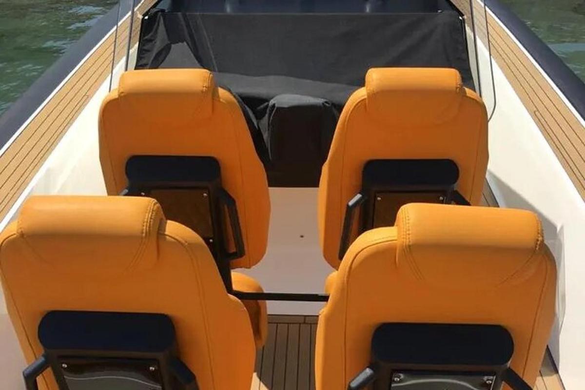 ein leeres Boot mit orangefarbenen Sitzen auf dem Wasser