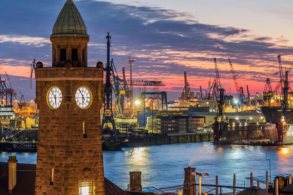 un turn cu ceas lângă un port cu un oraș