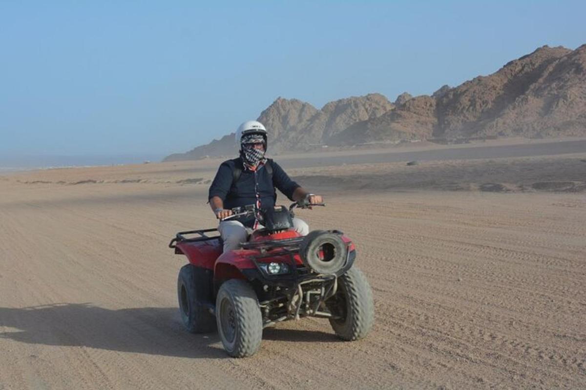un uomo che guida un quad nel deserto