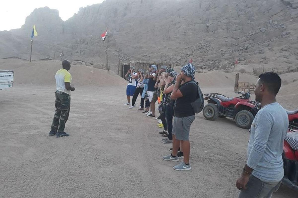un gruppo di persone in piedi attorno a un uomo che fa volare un aquilone