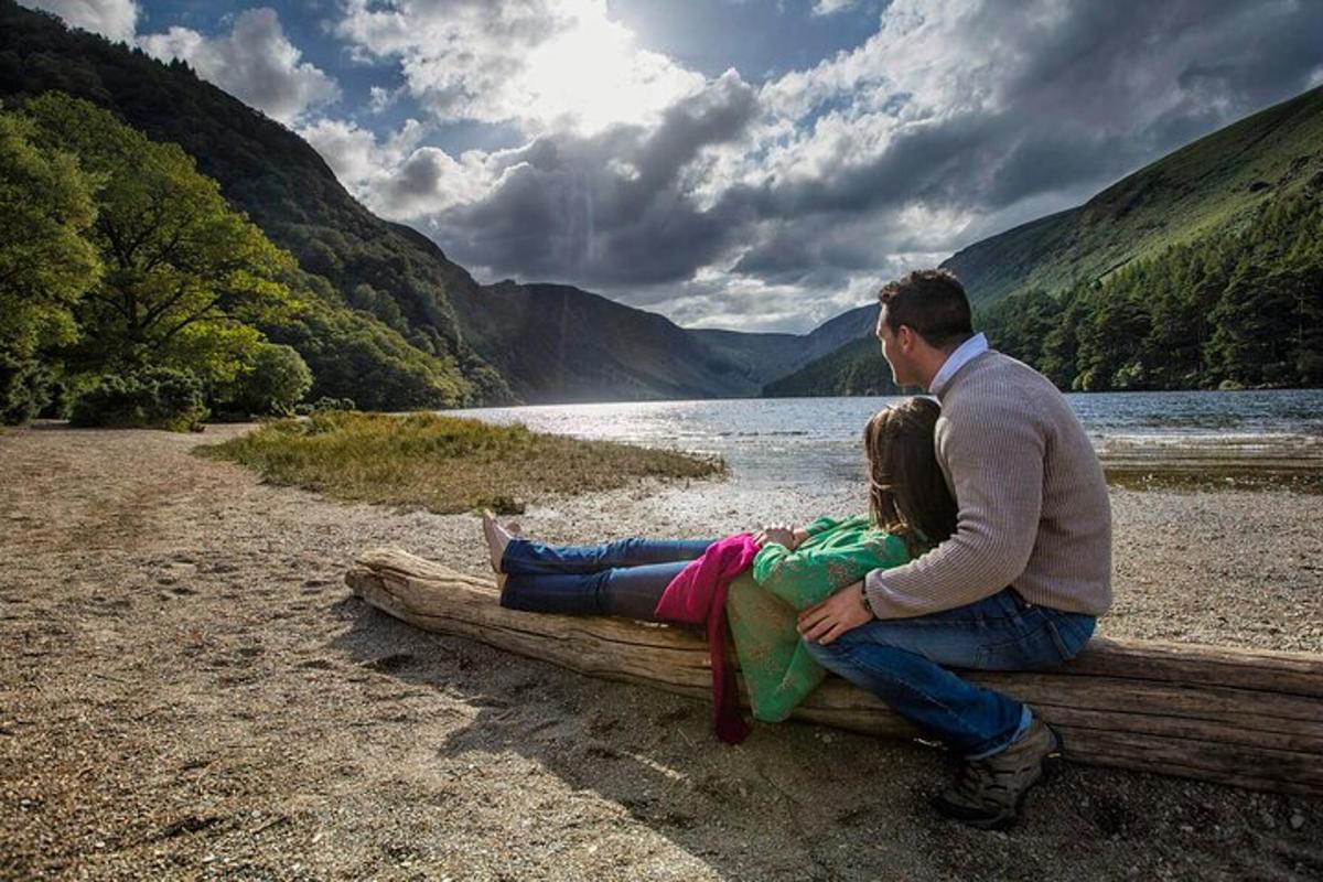 a man and a woman sitting on a bench by a lake