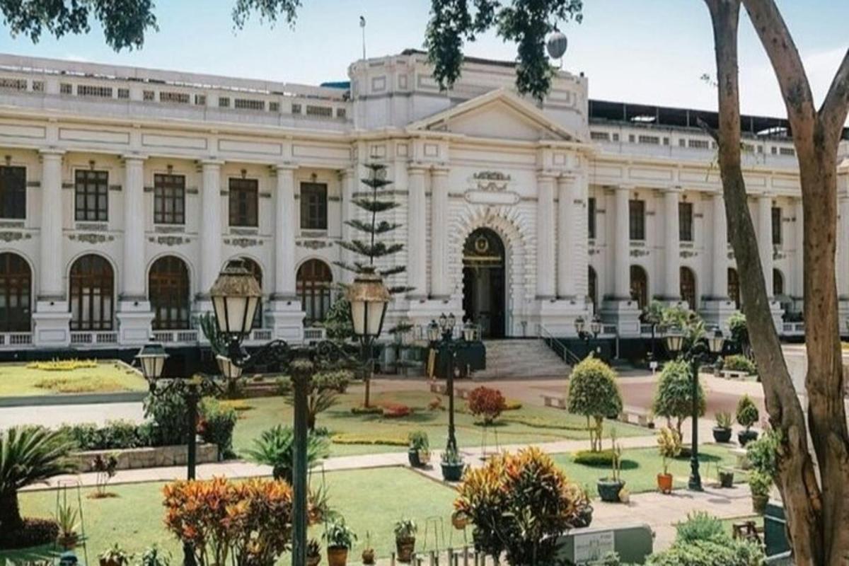 ένα μεγάλο λευκό κτίριο με δέντρα μπροστά του