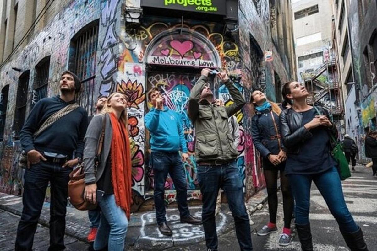 Μια ομάδα ανθρώπων που στέκονται μπροστά από ένα κτίριο με γκράφιτι