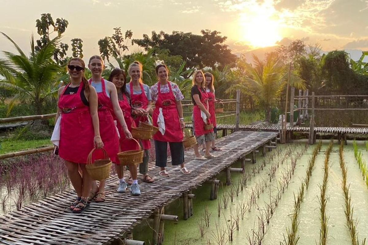 Un grupo de mujeres de pie sobre un puente de bambú.