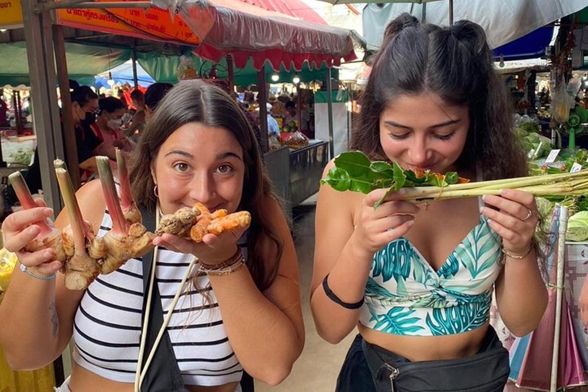 Dos mujeres comiendo comida con palillos en un mercado