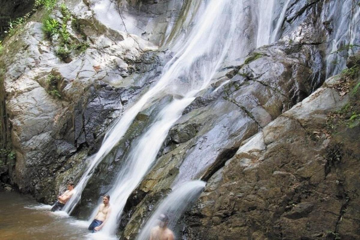 dua orang berdiri di air di air terjun