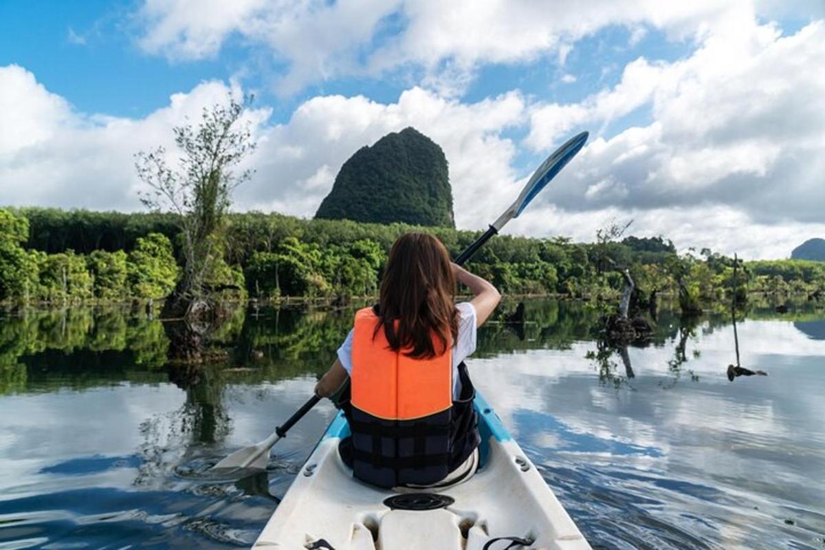 una donna sta pagaiando in canoa su un fiume