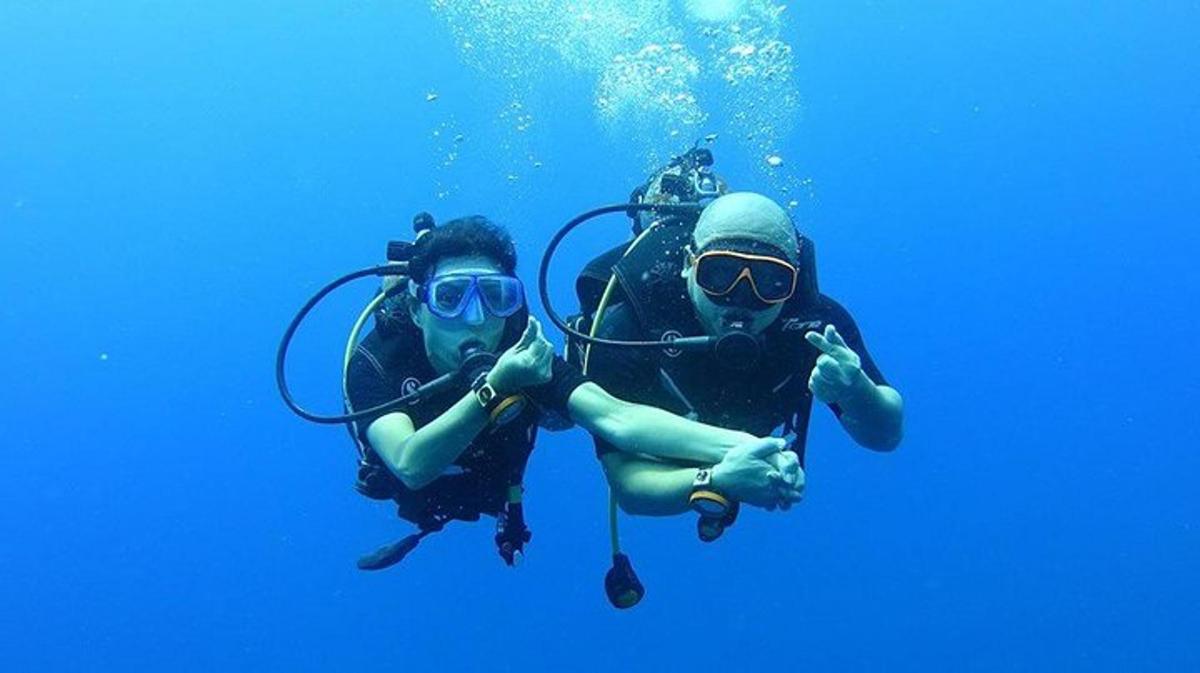 two people are posing for a picture in the water