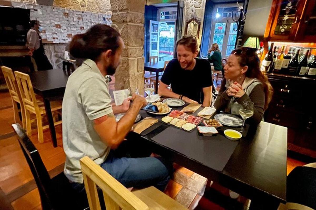grupė žmonių, sėdinčių prie stalo ir valgančių maistą