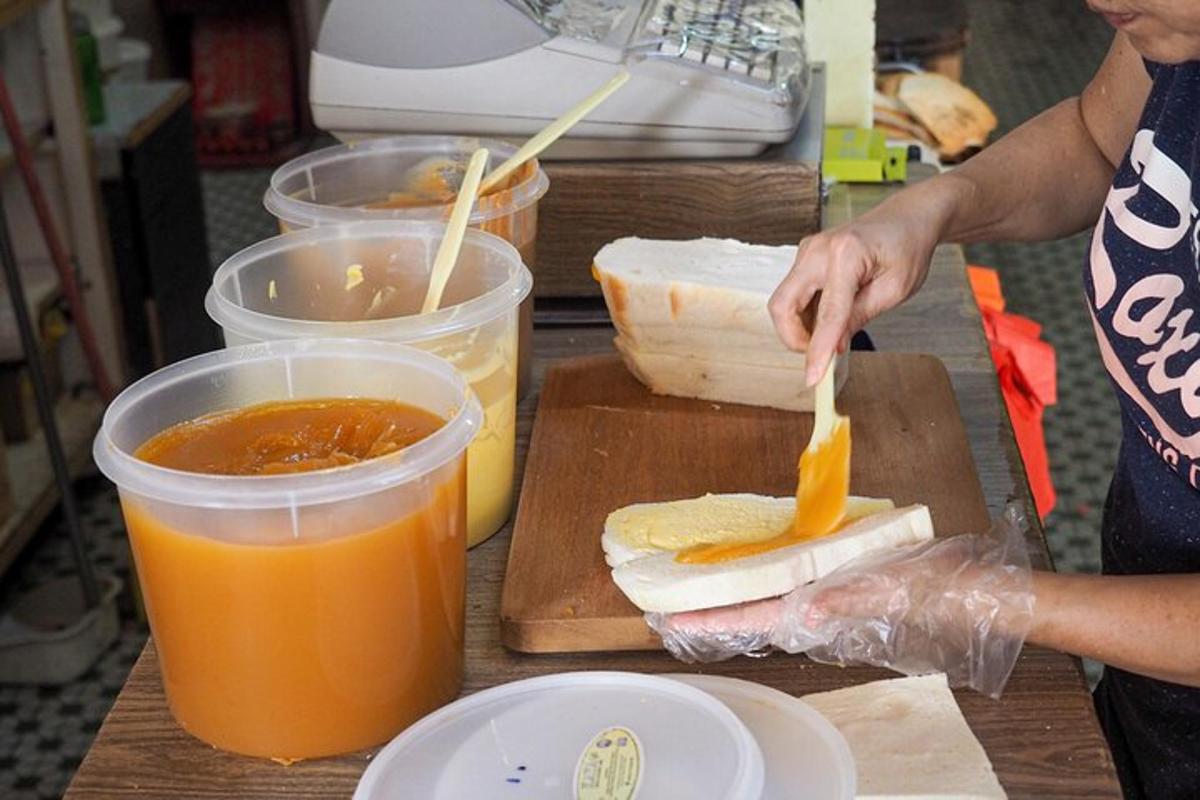 o femeie face un sandviș pe o placă de tăiat