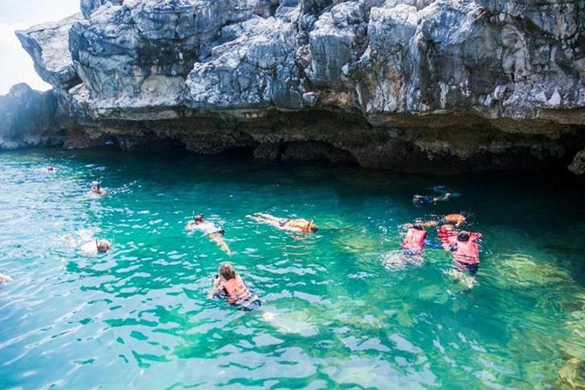 un gruppo di persone in acqua vicino a una grotta