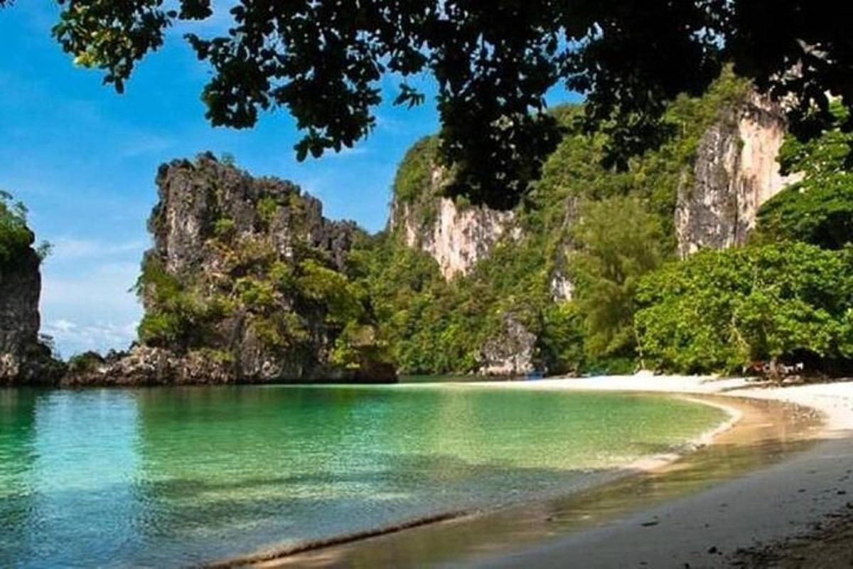 una spiaggia con acqua verde e scogliere calcaree