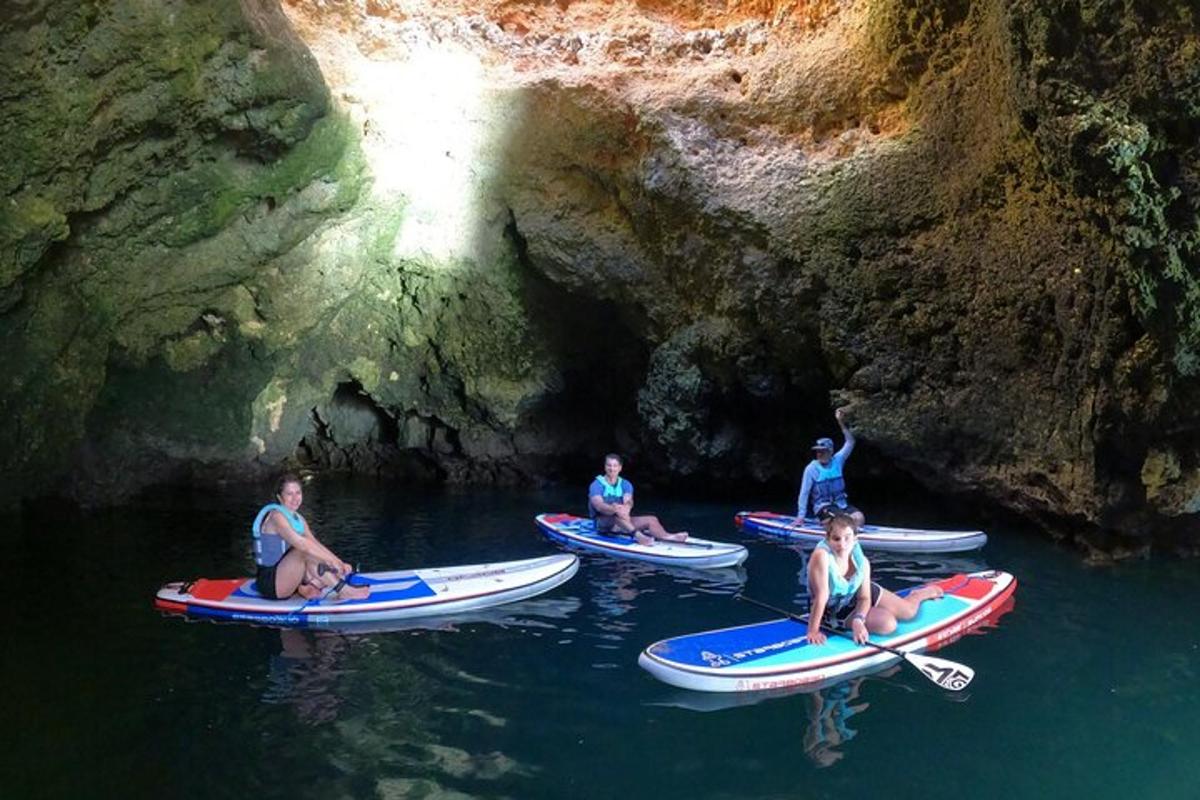um grupo de pessoas sentadas em caiaques em uma caverna