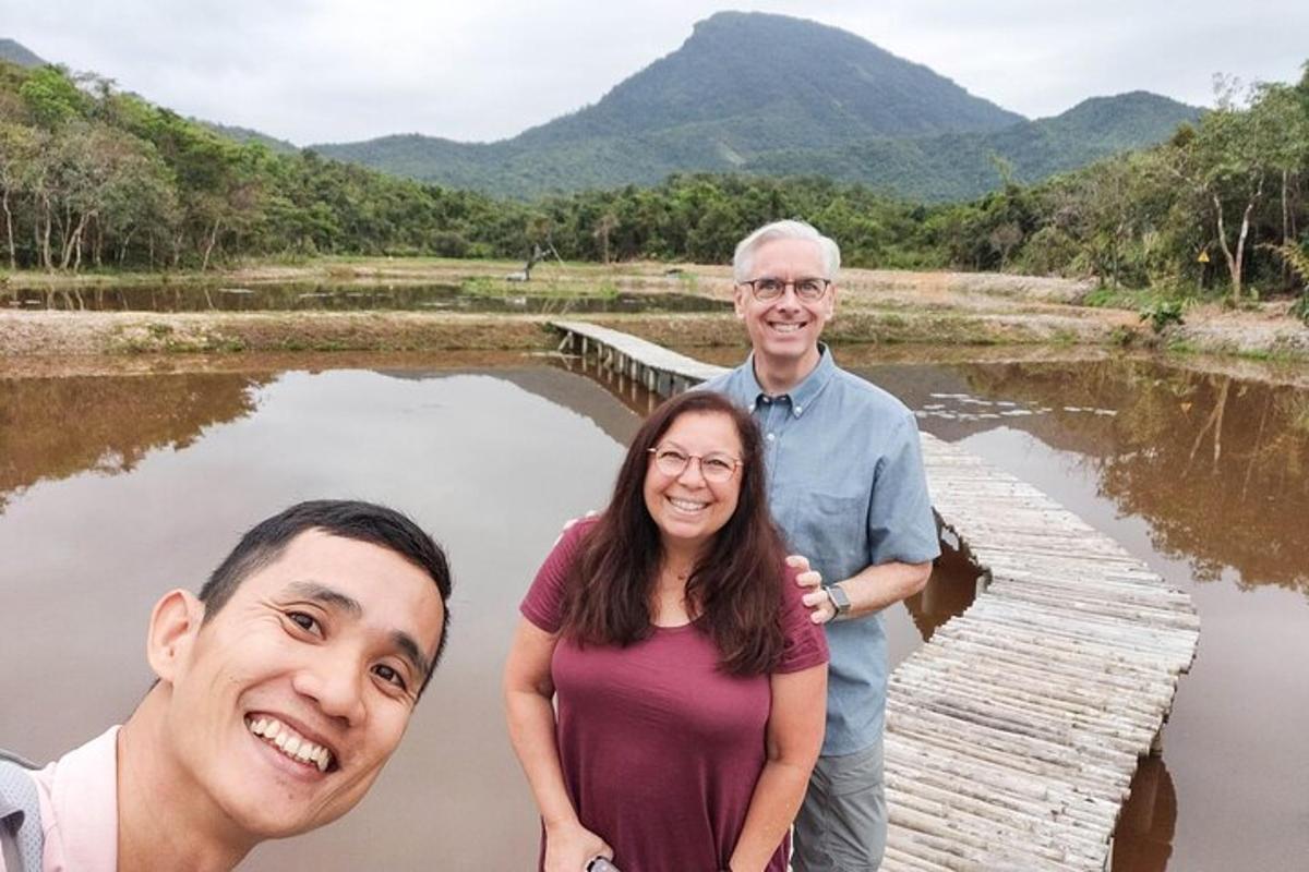 seorang lelaki dan seorang wanita berdiri di atas jambatan di atas tasik