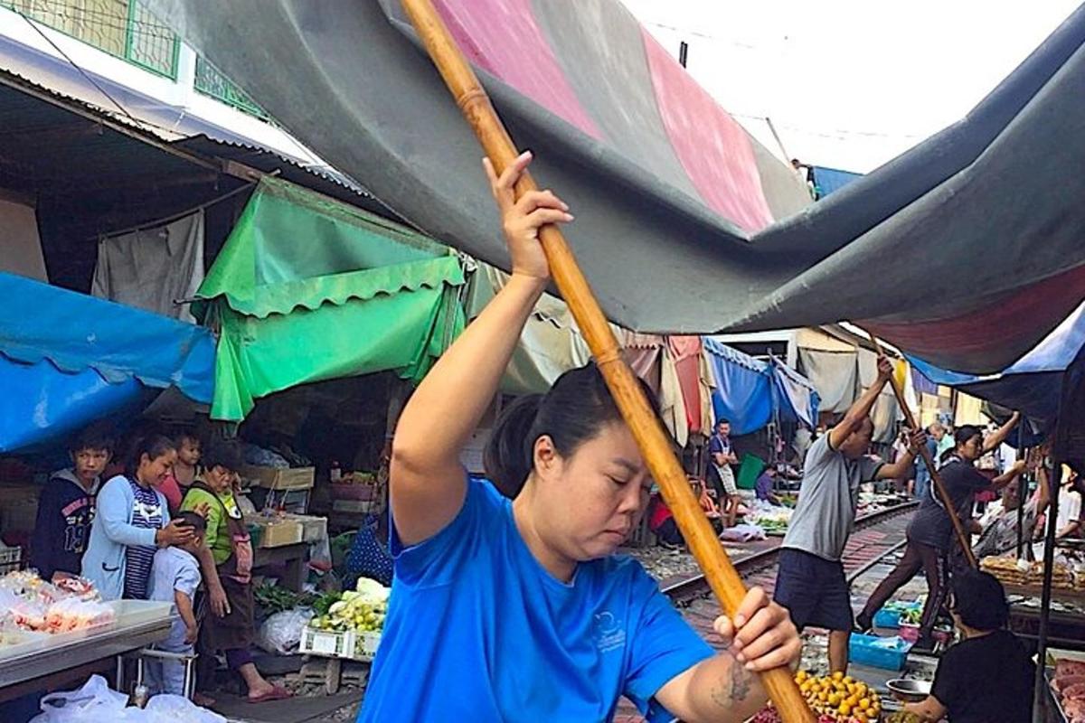 a young boy holding up an umbrella in a market