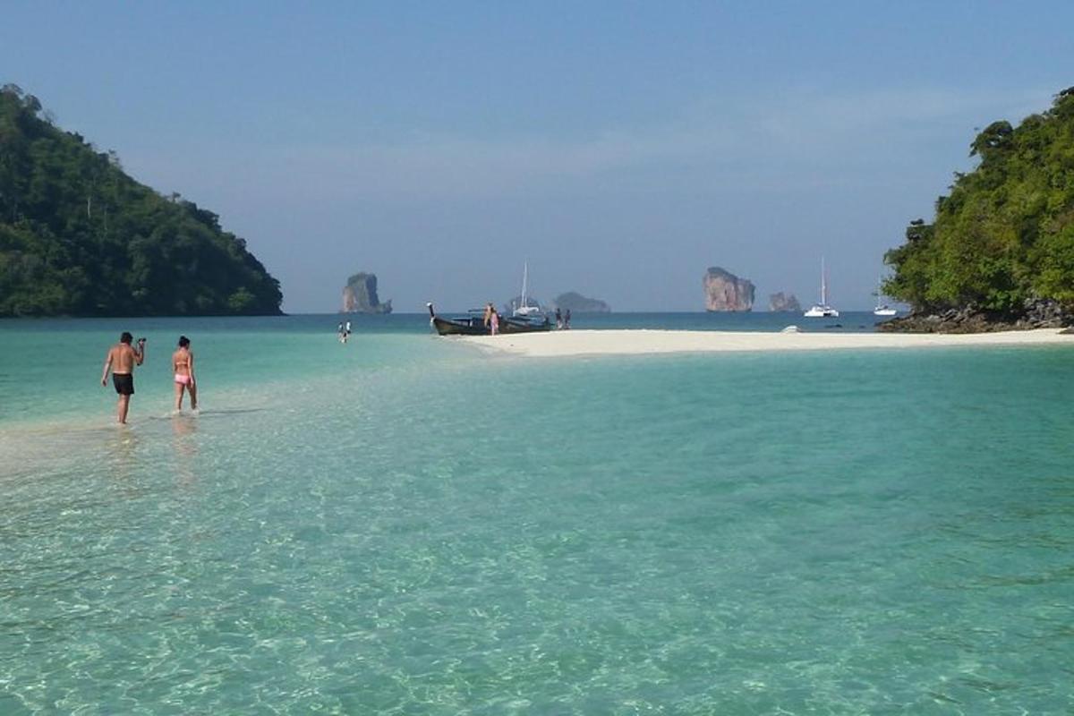 dua orang berjalan di dalam air di pantai